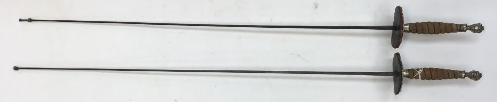 A pair of 19th century European fencing swords with ornate white metal guards, One blade stamped ‘