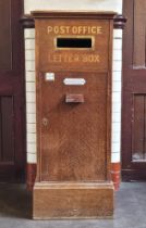 A large Edwardian oak hall post box, the moulded top above panel with brass letter aperture