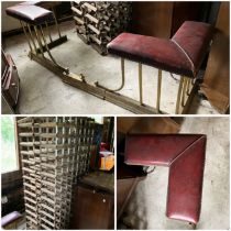 A brass adjustable fender with red leather corner seating plus two large wine racks 100 plus bottles