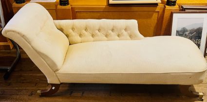 A 20th Century upholstered chaise lounge, scrolling button back rest, raised on regency sabre