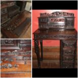 Small carved ebonised possibly mahogany desk with single pedestal and two supporting carved legs,