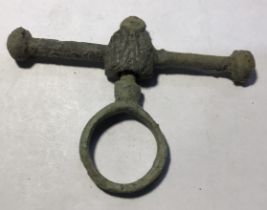 Post-medieval copper alloy purse bar with a circular swivelling loop and a shield-shaped boss. The