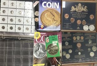 Framed coins with coin reference books and booklets with an empty coin album filled with coin
