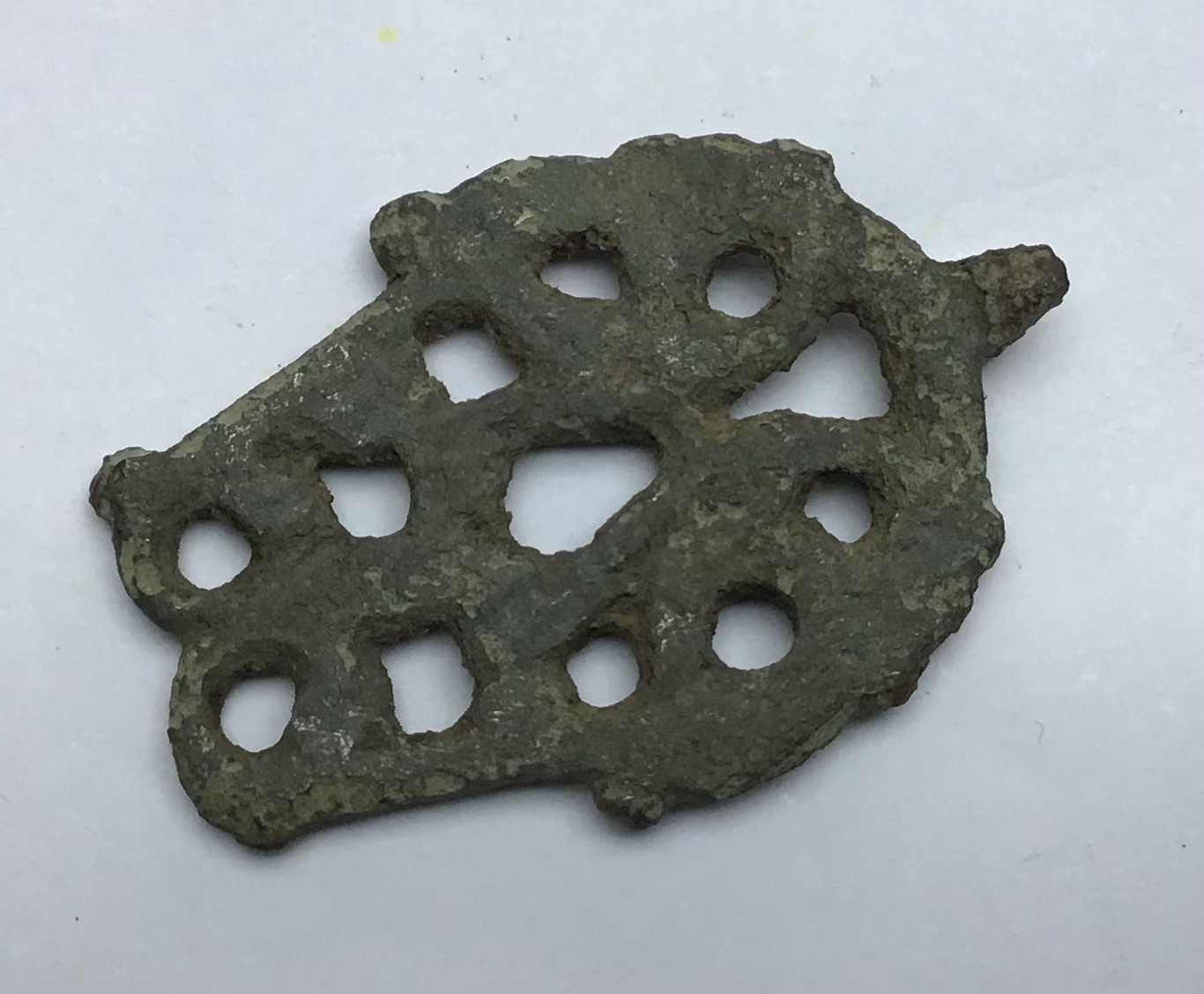 Incomplete medieval copper alloy openwork harness pendant in rather worn condition. The upper part