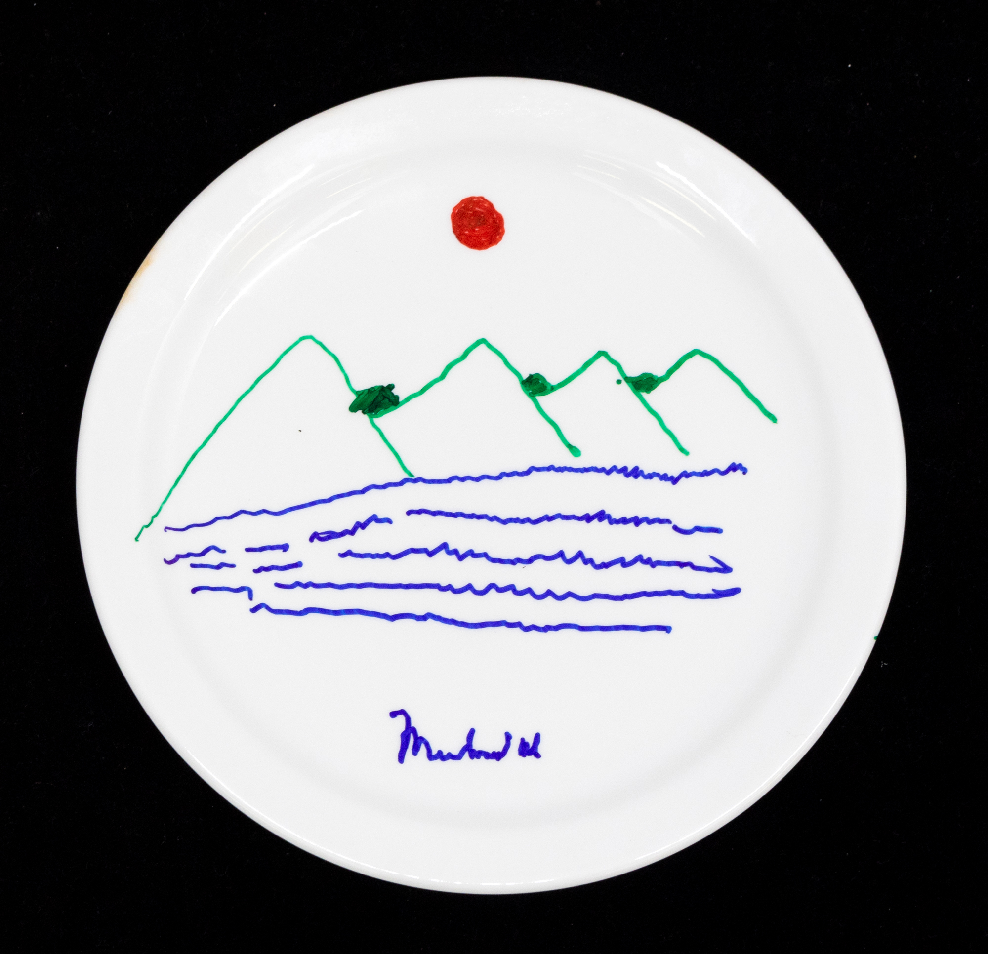 Muhammad Ali: A signed white ceramic plate, Muhammad Ali, with landscape scene in blue, red and