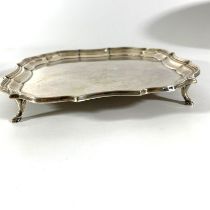 A silver salver, on four feet with a pie crust rim. Hallmarked for The Barker Brothers, Chester