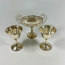 A silver sweet meat twin handled footed bowl, approx 14cm tall. Pair of silver goblets approx 10cm