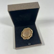 A gilt metal swivel mourning brooch missing a panel.