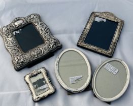 A group of five sterling silver glazed photograph frames. Featuring frames ranging in size from 19.