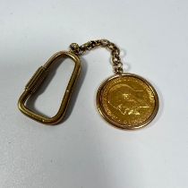 A George IV gold full sovereign dated 1912 in a 9ct mount on a gilt metal chain and a key ring,