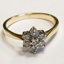A diamond ring set in a flower shape set in gold metal. Approximately 0.03ct. Ring size M.
