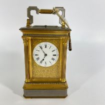 A good quality brass and gun metal carriage clock striking on a gong with repeat - approx 20cm tall,