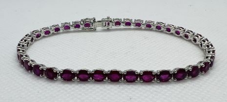 ***** AWAY TO VENDOR**** A ruby line bracelet featuring 38 oval mixed cut rubies, set into white