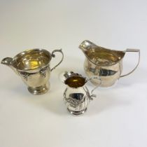 A Georgian Silver Milk Jug - approx 9cm tall and two later jugs. Total approx 302grams.