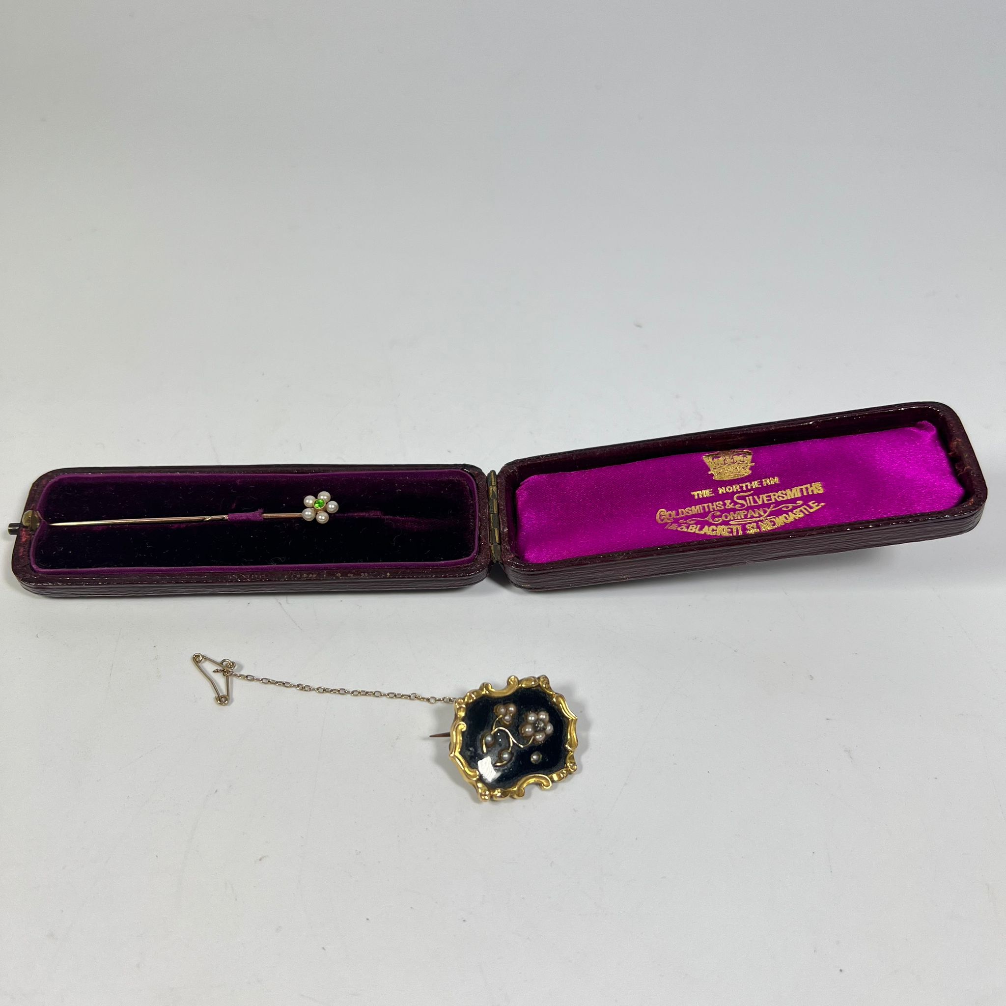 A gilt metal mourning brooch in worn condition, approx 25mm wide and a pretty pearl pin in a