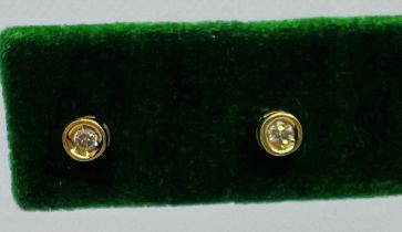 A pair of diamond stud earrings. Each set with an estimated 0.03 carat round brilliant cut. One