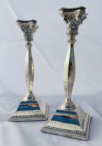 A pair of sterling silver square based candlesticks. Measuring approximately 26cm in height and with