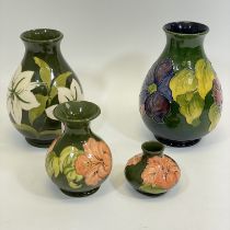 Four Moorcroft green ground vases. Approximate sizes: 21cm, 20cm, 13cm and 7cm. Some crazing