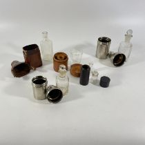 5 various bottles in holders: two metal/two wood/one leather.