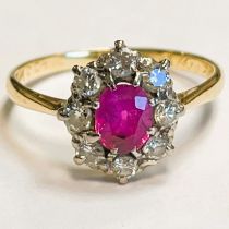Oval ruby type stone and diamond ring. Single ruby type stone surrounded by eight diamonds set in