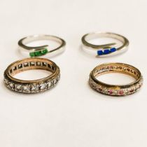 Four rings to include: Two silver metal rings (one set with 3 emeralds, one set with sapphire