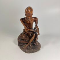 An Oriental wooden root carving - the Emaelated Man, approx 21cm tall. Minor losses but with a