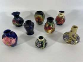 A collection of eight small Moorcroft vases, tallest approximately 10cm. Some crazing but