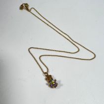 An 18ct yellow gold diamond pendant on a 9ct yellow gold (approx) 40cm chain and a gilt teddy bear