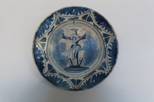 An 18th century Delftware large plate depicting the crucifixion, restored and drilled, diameter 30.