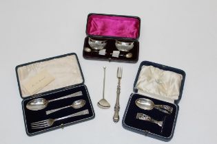 A cased pair of silver navette shape salts with scallop bowl spoons, a cased spoon and pusher, a