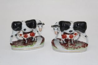 A pair of Staffordshire flatback mantle ornaments, each of a cow and calf beside a flowing stream,