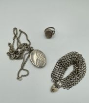A collection of silver jewellery comprising a locket and chain, a poison ring and a padlock