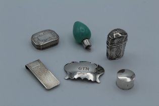 A group of small silver items, including a spirit label, vinigrettes, etui case, money clip and a