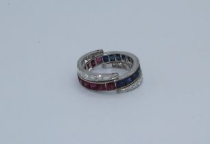 An unmarked platinum metamorphic ring, hinged and channel set with rubies, sapphires and diamonds.