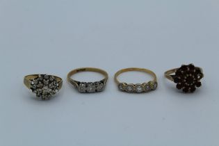 A collection of four dress rings. To include two 9ct gold cluster rings, one set with cubic