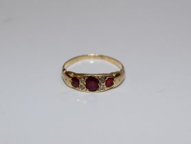 An Edwardian three stone ruby ring. The principal stone approximately 3 x 5mm to a gold shank. Gross