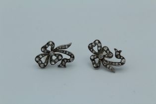 A pair of Victorian rhodium plated, silver and gold, diamond set bow form earrings. Maximum length