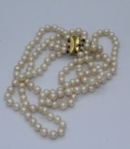 A three strand uniform cultured pearl chocker necklace. The 5mm diameter pearls of pinky cream
