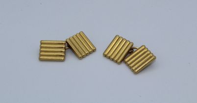 Cartier, a pair of early 20th century 18 carat gold cufflinks, each face of rectangular reeded form.