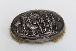 An early 20th century Indian silver mounted brush, decorated with figures in howdah and elephants,