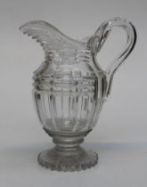 An early 19th century English cut lead crystal water jug, with slice cut neck and body, loop