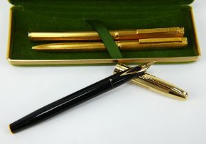 A Dunhill gold plated fountain pen and ballpoint pen set and a Sheaffer fountain pen.