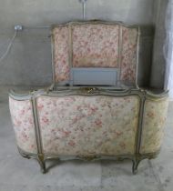 Ornate French double bed with floral upholstered panels and carved ends and side rails.