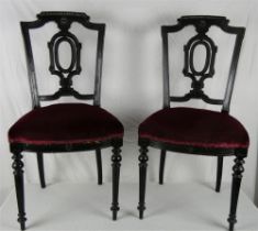 A pair of Edwardian ebonised occasional chairs, with decorative pierced carved backs