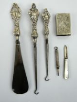 Two silver handled buttons hook, a shoe horn, silver pencil, silver fruit knife & a plated vesta.