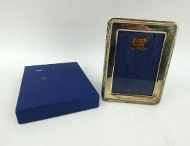 A hallmarked silver photo frame, 16cm x 12cm. Hallmarked for Birmingham 1994. Boxed.