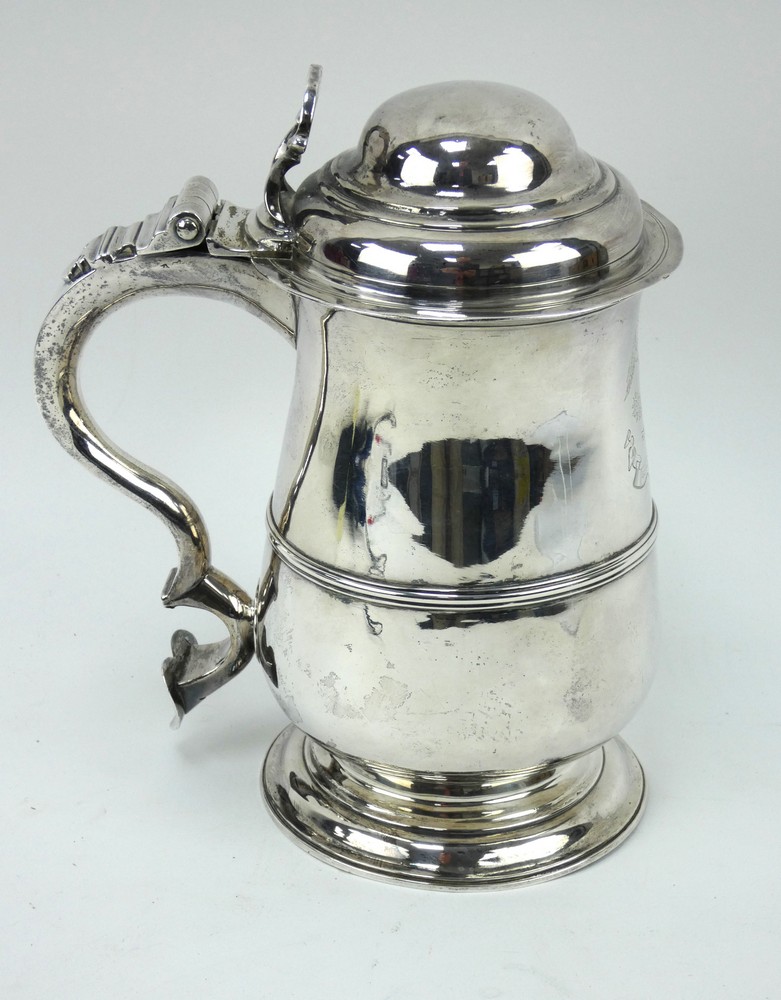 A George III silver quart tankard of baluster form with domed lid and scroll handle. Hallmarked 1765