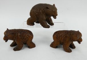 Three Japanese carved hardwood bear figures, each with inset glass eyes. Largest bear is signed