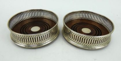 A pair of Georgian style silver wine coasters with mahogany bases. Hallmarked for London 1990
