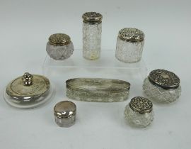 Eight antique hallmarked silver topped vanity glass jars of various size and style.